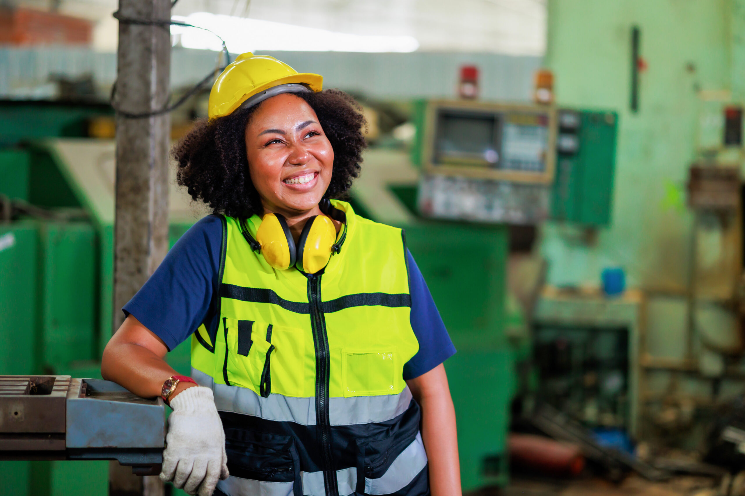 Portrait african american female engineer worker wearing safety hard hat helmet. Metal lathe industrial manufacturing factory